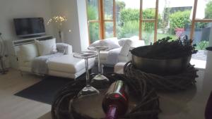 K82 apart HOTEL relax&work في Kirchentellinsfurt: غرفة معيشة مع أريكة وطاولة مع كؤوس للنبيذ