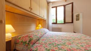 a bedroom with a bed and a lamp and a window at RESIDENCE MARCO POLO in Eraclea Mare +18 photos