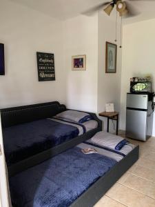 1 dormitorio con 2 camas y una pizarra en la pared en Apartamento Estudio Casa Maria Reyes en Bayamon, en Van Scoy