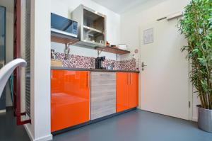 una cocina con armarios de color naranja y plata en K314 en Bonn