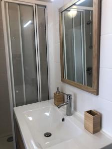 a bathroom sink with a mirror and a shower at Duplex centre ville 200m de la plage in Dinard
