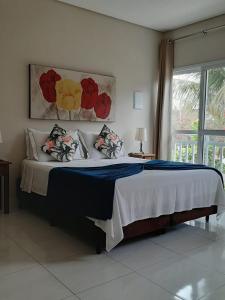 1 cama grande en un dormitorio con ventana en Flats Premium Jabaquara, en Paraty