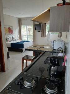 Habitación con cocina y dormitorio con cama. en Flats Premium Jabaquara, en Paraty