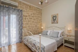 1 dormitorio con cama y pared de ladrillo en Casa Belvedere Apartments, en Kournás