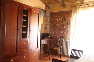 a room with a wooden cabinet and a desk with a chair at Hotel Rural Cerro Principe in La Garrovilla