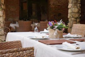 una mesa con platos, servilletas y flores. en Hotel Rural Cerro Principe en La Garrovilla