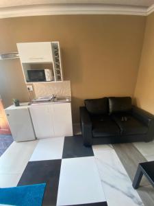 a living room with a couch and a microwave at Ext4 Guest house in Roodepoort