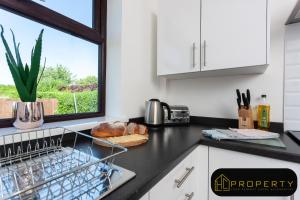 a kitchen counter with a dish drying rack and a window at H C Property - Mountford - Contractors, Families and couples welcome in Durham