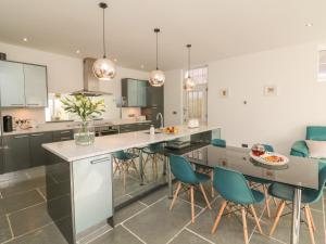 a kitchen with a large island with blue chairs at The Old Coach House in Braunton