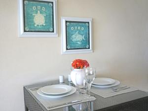 a dining table with two plates and a vase with flowers at Lantana Resort Barbados by Island Villas in Saint James