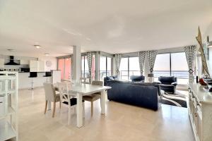 Il comprend une cuisine et un salon avec une table et des chaises. dans l'établissement Magnifique appartement vue mer, à Valras-Plage