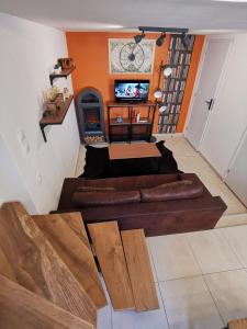 sala de estar con sofá marrón y paredes de color naranja en Hebergeneve La belle vie, en Gex