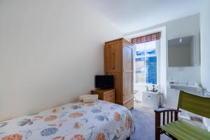 a bedroom with a bed and a sink and a window at Thorneyfield Guest House in Ambleside