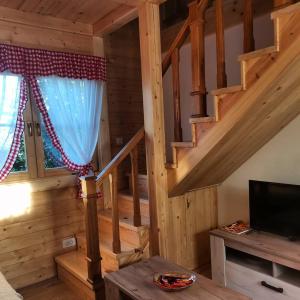 ein Wohnzimmer mit einer Treppe in einem Blockhaus in der Unterkunft BRVNARE STOJIĆ in Kokin Brod