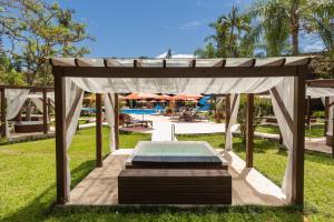 a gazebo with a pool in the grass at Hotel Internacional Gravatal in Gravatal