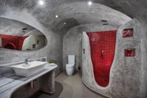 a bathroom with a sink and a red shower at Katerina's Castle - Caldera Cave Hotel in Imerovigli