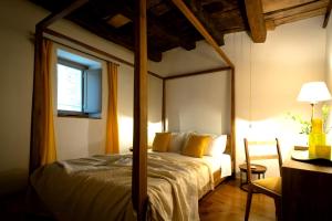 1 dormitorio con cama con dosel y almohadas amarillas en pietre di ASPRA, en Casperia