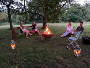 a group of people sitting around a fire pit at Truly Kentish Holiday Lets in Kent