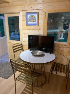a room with a table and chairs and a television at Truly Kentish Holiday Lets in Kent