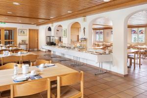 a restaurant with tables and chairs and a counter at Hotel & Bildungshaus St. Jodern in Visp