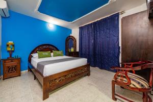 een slaapkamer met een bed en een blauwe muur bij Hotel Ayenda Eclipse 1706 in Villavicencio