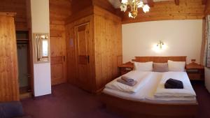 ein Schlafzimmer mit einem großen Bett in einem Holzzimmer in der Unterkunft Bauernhof Oberscheffau in Neukirchen am Großvenediger