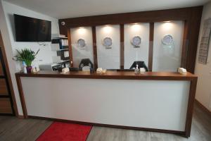 a reception desk in a hotel room with a television at Hotel Hausen Obertshausen Frankfurt in Obertshausen