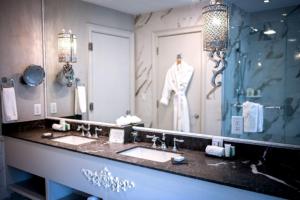 uma casa de banho com 2 lavatórios e um espelho grande em The Ivey's Hotel em Charlotte