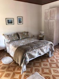 un dormitorio con una cama grande en una habitación en Pousada Pedacinho do Ceu chale 2, en Cunha