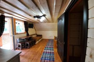 ein Zimmer mit Sofa und Tisch in einem winzigen Haus in der Unterkunft Номер 6 Садиба У Ані in Synewyrska Poljana