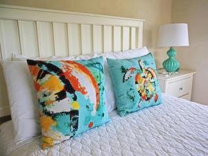 a bed with two colorful pillows on it at Lantana Resort Barbados by Island Villas in Saint James