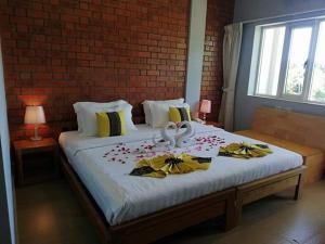 a bedroom with a large bed with flowers on it at The Pegu Lodge in Bago