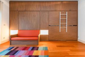 een oranje bank in een kamer met een ladder bij FLH S Bento Foldable Color Studio in Lissabon