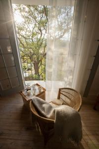 een kamer met een stoel, een tafel en een raam bij Kogman & Keisie Guest Farm in Montagu