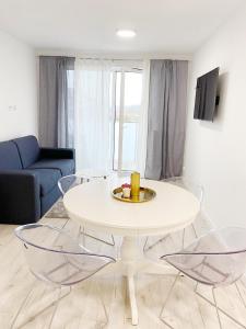 een woonkamer met een witte tafel en 2 stoelen bij APARTAMENT PRZY WYDMIE in Grzybowo