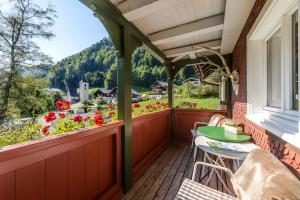 a balcony with a table and chairs and flowers at Café Pension zum Jäger in Buchboden