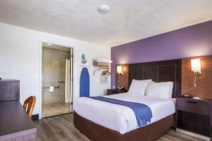 Habitación de hotel con cama grande y baño. en Rodeway Inn near Downtown Monterey, en Monterey
