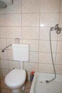 a white toilet sitting in a bathroom next to a tub at Ośrodek Wypoczynkowy Jelonek in Wolsztyn