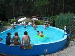 people playing in a swimming pool at Ośrodek Wypoczynkowy Jelonek in Wolsztyn
