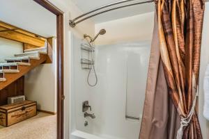 ein Bad mit einer Dusche und einem Duschvorhang in der Unterkunft Cozy one bedroom with privacy - Community beach access in Sandpoint