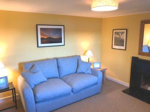 Northern Lights في Talmine: أريكة زرقاء في غرفة المعيشة مع موقد