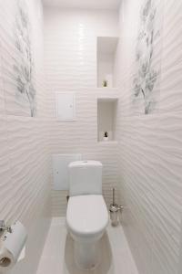 a white bathroom with a toilet and a sink at PaulMarie Apartments on Gor'kogo 41 in Bobruisk