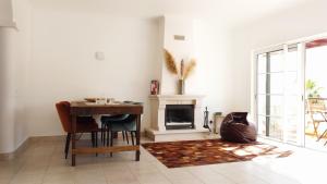 a living room with a table and a fireplace at Komfortables Town House in traumhafter Lage in Budens