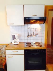 RattendorfにあるHaus Philippitschのキッチン(黒いコンロ、白いキャビネット付)