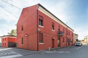a red building on the side of a street at Dimora Tipica Ferrarese in Ferrara