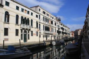 un gruppo di barche parcheggiate in un canale accanto agli edifici di Casa Caburlotto a Venezia