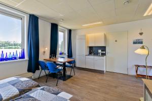 een kamer met een keuken en een tafel en stoelen bij B & B Leudal in Haelen