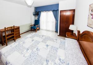 a bedroom with a bed and a desk and a chair at Hotel Restaurante Xaneiro in Melide