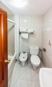 a white bathroom with a toilet and a sink at Hotel Restaurante Xaneiro in Melide +25 photos