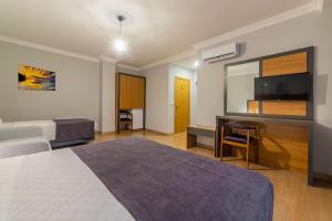 a hotel room with two beds and a desk and a mirror at Antalya Business Hotel in Antalya